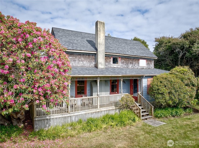 209 3rd St SE, Long Beach, WA 98631 - view of front of house with covered porch, a shingled roof, and a chimney