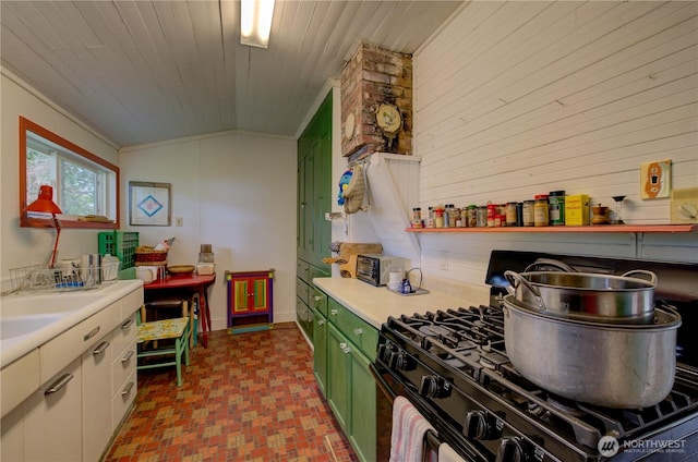 209 3rd St SE, Long Beach, WA 98631 - kitchen with black gas range, green cabinets, light countertops, wood walls, and ornamental molding