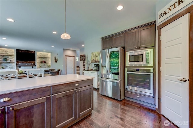 13131 287th Ave SE, Monroe, WA 98272 - kitchen with stainless steel appliances, dark brown cabinetry, dark wood finished floors, light countertops, and pendant lighting