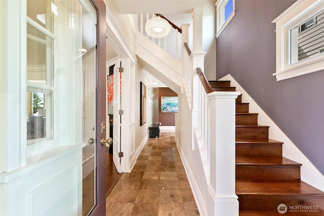 1634 Palm Ave SW, Seattle, WA 98116 - staircase featuring stone finish floors, healthy amount of natural light, and a towering ceiling