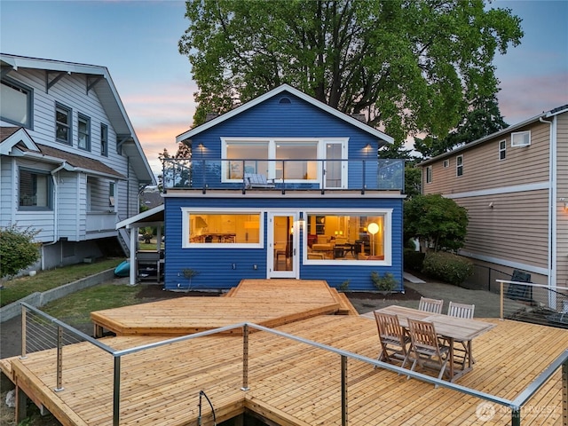 1634 Palm Ave SW, Seattle, WA 98116 - back of property at dusk featuring a balcony, a wooden deck, and outdoor dining area