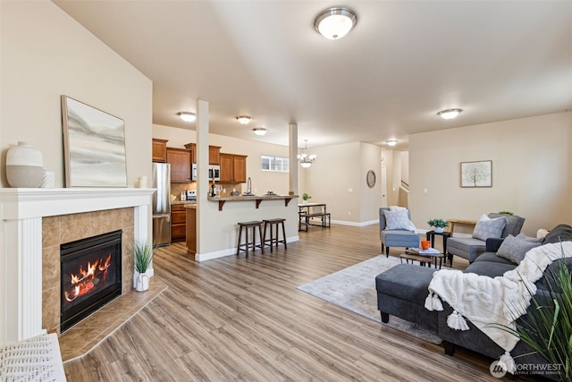 4444 Edgewater Blvd NE, Lacey, WA 98516 - living area featuring light wood-type flooring, a chandelier, and a tiled fireplace
