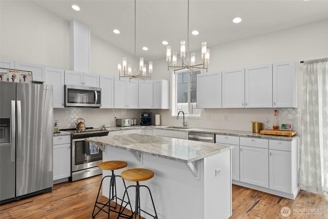 1828 Kristina Ln, Wenatchee, WA 98801 - kitchen with stainless steel appliances, a chandelier, a center island, a kitchen bar, and decorative backsplash
