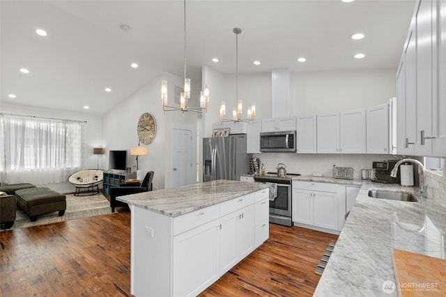 1828 Kristina Ln, Wenatchee, WA 98801 - kitchen with appliances with stainless steel finishes, high vaulted ceiling, open floor plan, a center island, and a chandelier