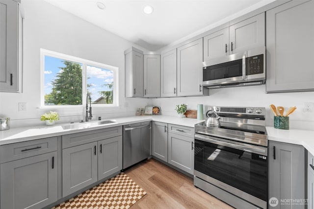 12105 E Gibson, Everett, WA 98204 - kitchen with stainless steel appliances, gray cabinetry, light countertops, light wood-type flooring, and recessed lighting