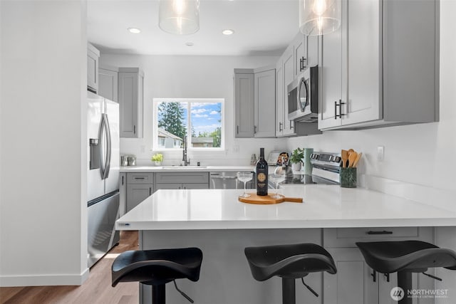 12111 E Gibson, Everett, WA 98204 - kitchen featuring appliances with stainless steel finishes, gray cabinets, a peninsula, a breakfast bar, and recessed lighting