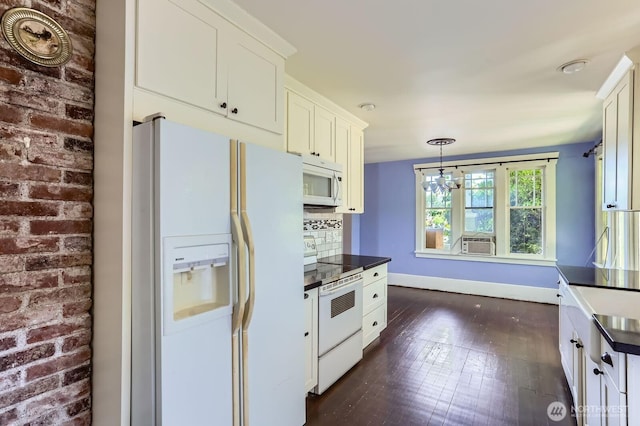 26405 Stephens St, Duvall, WA 98019 - kitchen with white appliances, dark countertops, cooling unit, white cabinetry, and brick wall