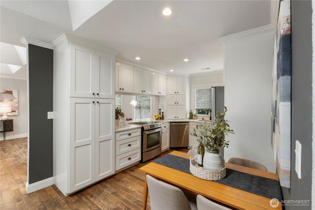 23305 98th Ave S, Kent, WA 98031 - kitchen featuring appliances with stainless steel finishes, crown molding, light countertops, white cabinets, and wood finished floors
