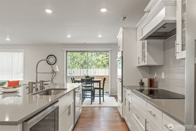21124 42nd Dr SE, Bothell, WA 98021 - kitchen featuring appliances with stainless steel finishes, recessed lighting, custom exhaust hood, wood finished floors, and white cabinetry