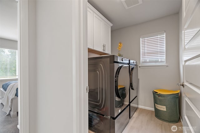 21124 42nd Dr SE, Bothell, WA 98021 - laundry area featuring independent washer and dryer, cabinet space, and healthy amount of natural light
