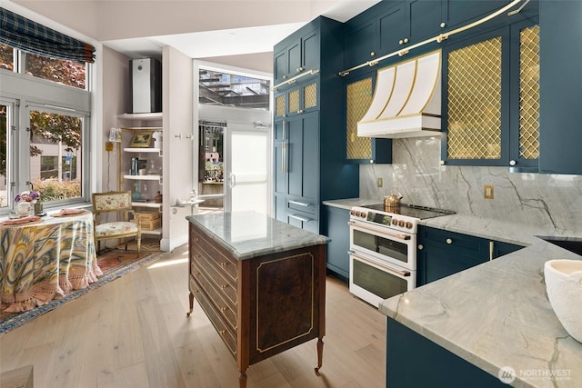 159 Denny Way Unit 112, Seattle, WA 98109 - kitchen with double oven range, custom range hood, light wood-style flooring, and light stone countertops