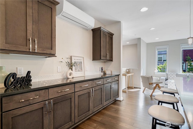 935 7th Ave NE Unit 17.3, Issaquah, WA 98029 - kitchen with a wall mounted air conditioner, dark countertops, dark wood-type flooring, dark brown cabinets, and recessed lighting