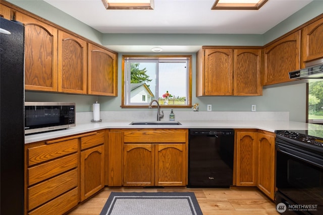 20063 Park Ridge Ln, Sedro Woolley, WA 98284 - kitchen with black appliances, light countertops, light wood finished floors, and brown cabinetry