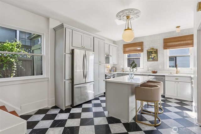 2233 2nd Ave W, Seattle, WA 98119 - kitchen featuring appliances with stainless steel finishes, dark floors, light countertops, and a center island