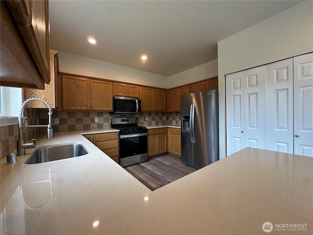 15328 104th Ave SE, Yelm, WA 98597 - kitchen with stainless steel appliances, brown cabinets, tasteful backsplash, light stone countertops, and recessed lighting