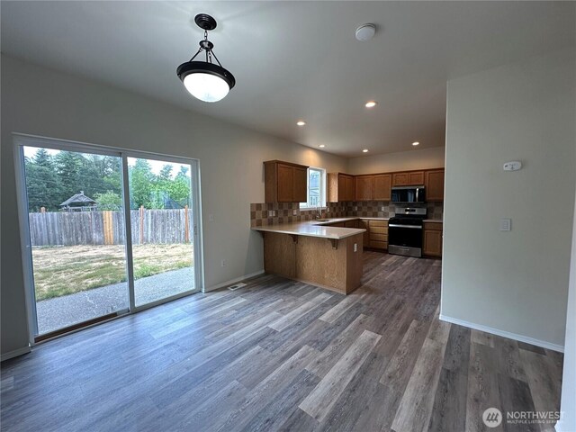 15328 104th Ave SE, Yelm, WA 98597 - kitchen with stainless steel appliances, a peninsula, light countertops, tasteful backsplash, and light wood-style flooring