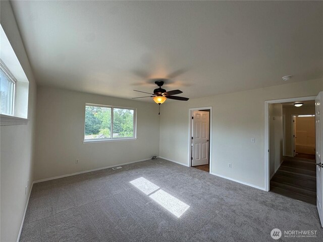 15328 104th Ave SE, Yelm, WA 98597 - unfurnished bedroom with dark colored carpet and ceiling fan