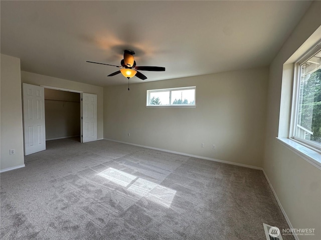 15328 104th Ave SE, Yelm, WA 98597 - unfurnished bedroom featuring carpet floors, multiple windows, a ceiling fan, and a closet