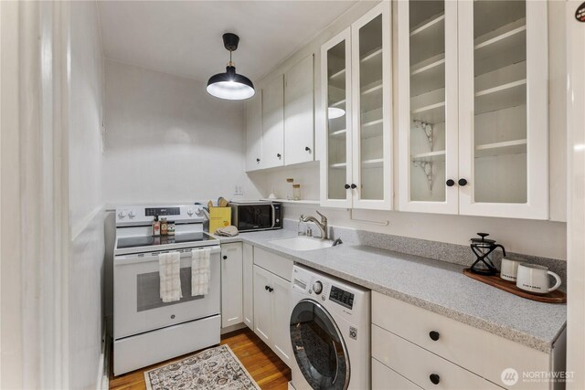 4725 15th Ave NE Unit 22, Seattle, WA 98105 - kitchen featuring washer / dryer, white range with electric stovetop, stainless steel microwave, white cabinets, and glass insert cabinets