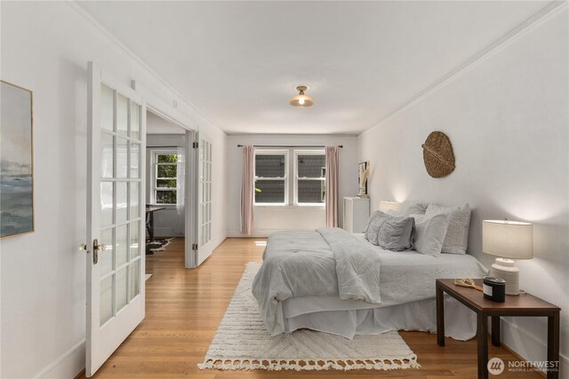 4725 15th Ave NE Unit 22, Seattle, WA 98105 - bedroom featuring french doors, light wood-style floors, and ornamental molding