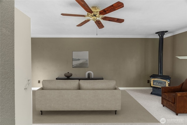 2717 Bench Dr, Aberdeen, WA 98520 - carpeted living room featuring a wood stove, ceiling fan, and ornamental molding