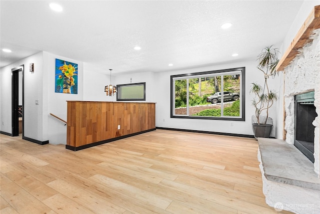 1668 Sapphire Trl, Bellingham, WA 98226 - unfurnished living room with a stone fireplace, light wood-style floors, recessed lighting, and a textured ceiling