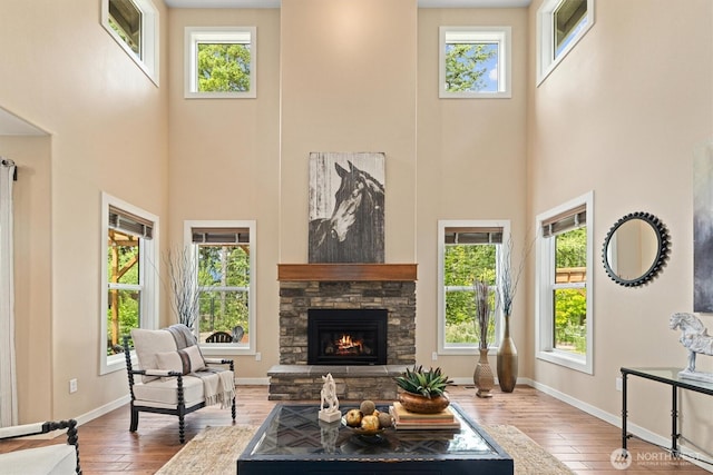 1635 Tannerwood Way SE, North Bend, WA 98045 - living area with a high ceiling, plenty of natural light, a stone fireplace, and wood-type flooring
