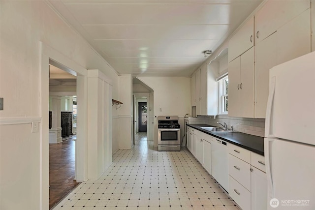 715 W Howe St, Seattle, WA 98119 - kitchen with white appliances, dark countertops, backsplash, light flooring, and white cabinets