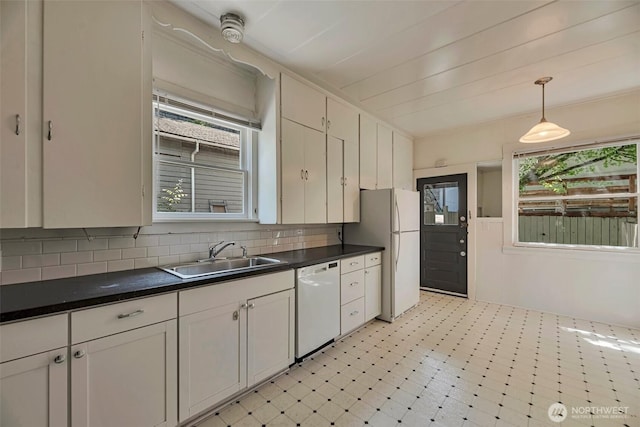 715 W Howe St, Seattle, WA 98119 - kitchen featuring white appliances, dark countertops, hanging light fixtures, backsplash, and light floors