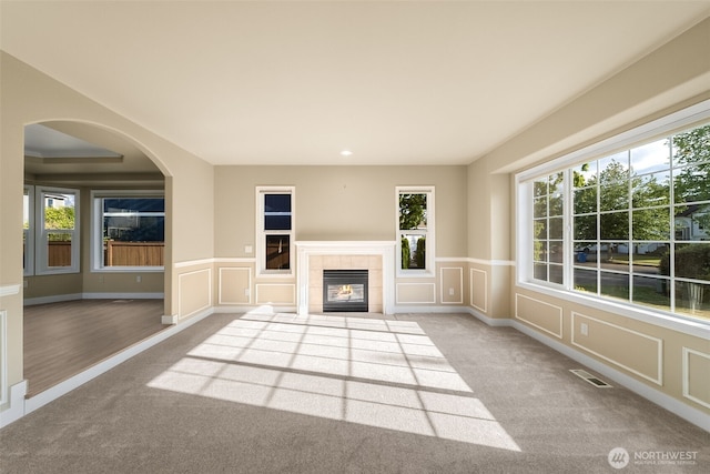456 Sorensen St, Buckley, WA 98321 - unfurnished living room with carpet floors, a decorative wall, plenty of natural light, a tiled fireplace, and a wainscoted wall