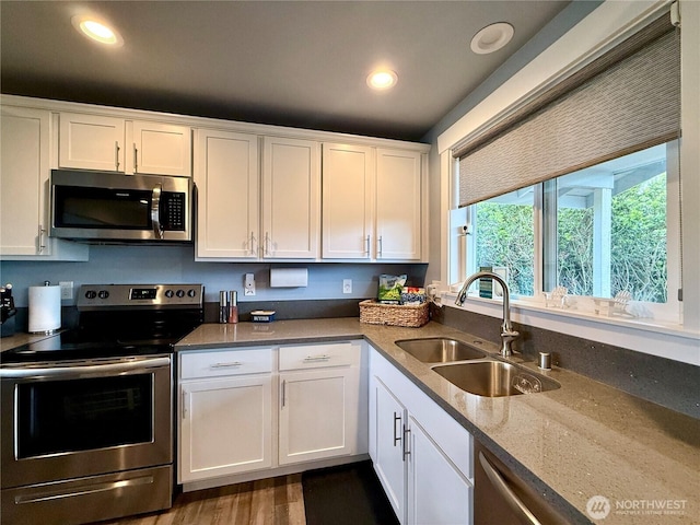 1155 Greenview Ave SW, Ocean Shores, WA 98569 - kitchen with appliances with stainless steel finishes, white cabinets, recessed lighting, dark wood finished floors, and stone countertops