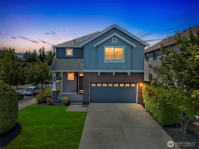 1130 77th Dr SE, Lake Stevens, WA 98258 - view of front of home featuring board and batten siding, brick siding, a front lawn, an attached garage, and driveway