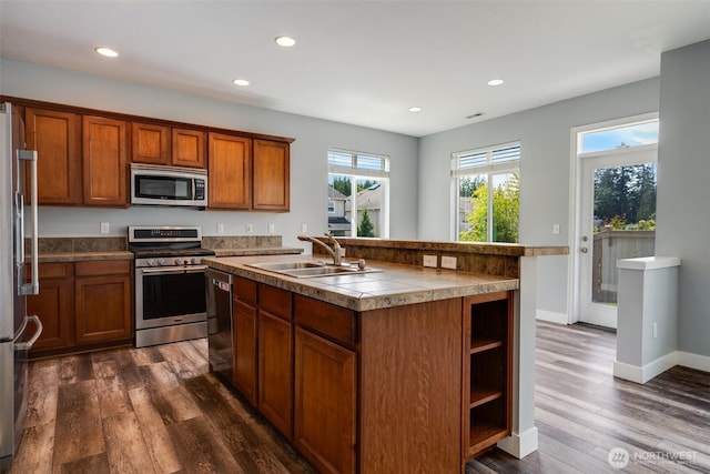 1130 77th Dr SE, Lake Stevens, WA 98258 - kitchen with appliances with stainless steel finishes, brown cabinetry, dark wood-style floors, recessed lighting, and an island with sink