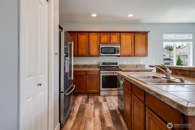 1130 77th Dr SE, Lake Stevens, WA 98258 - kitchen with appliances with stainless steel finishes, dark wood-style flooring, brown cabinets, and recessed lighting