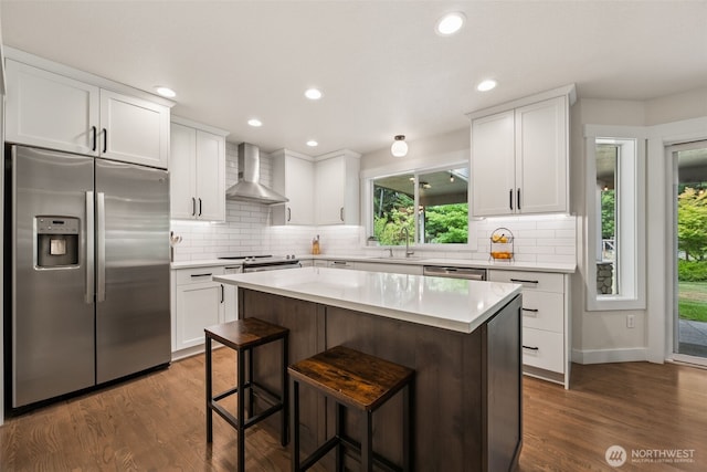 6518 73rd Ave E, Olympia, WA 98516 - kitchen featuring stainless steel appliances, wall chimney exhaust hood, white cabinets, light countertops, and tasteful backsplash