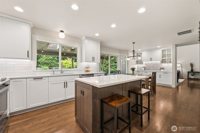 6518 73rd Ave E, Olympia, WA 98516 - kitchen with backsplash, dark wood-type flooring, white cabinetry, recessed lighting, and a kitchen island