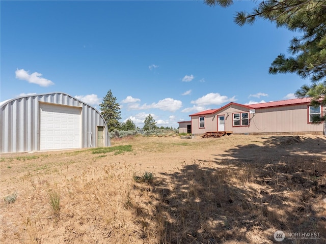 115 Hummingbird Rd, East Wenatchee, WA 98802 - view of yard featuring a detached garage, an outbuilding, and driveway