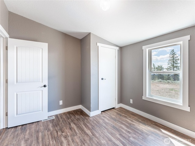 115 Hummingbird Rd, East Wenatchee, WA 98802 - unfurnished bedroom featuring wood finished floors, lofted ceiling, and a closet