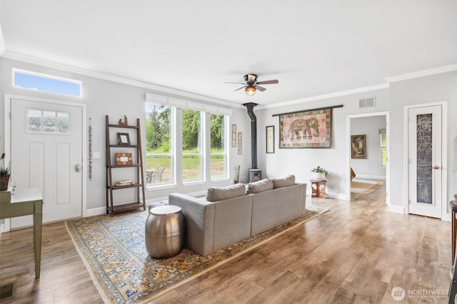 1966 Hooker Rd, Sequim, WA 98382 - living area featuring a wood stove, crown molding, a ceiling fan, and wood finished floors