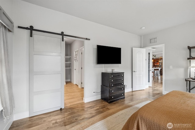 1966 Hooker Rd, Sequim, WA 98382 - bedroom featuring a barn door and wood finished floors