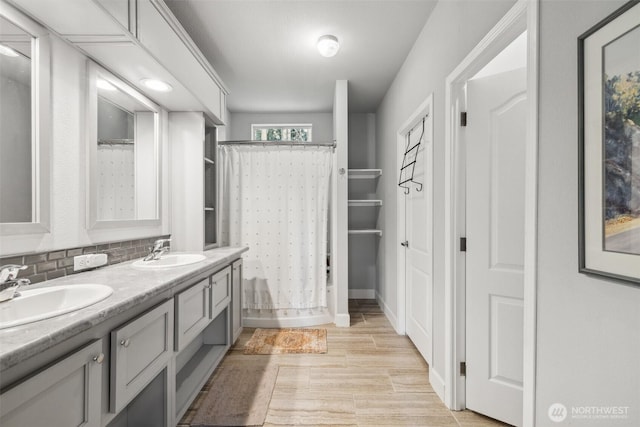 1966 Hooker Rd, Sequim, WA 98382 - bathroom with double vanity, curtained shower, tasteful backsplash, and wood finished floors
