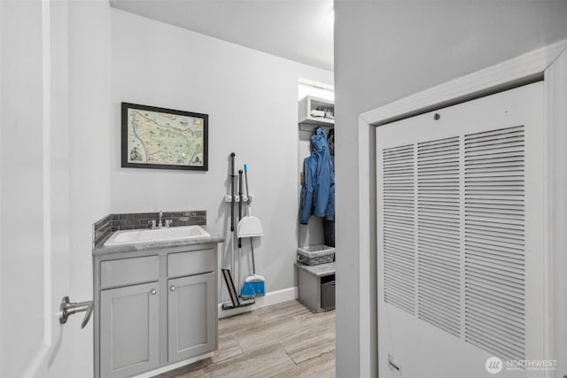 1966 Hooker Rd, Sequim, WA 98382 - bathroom with a heating unit, vanity, wood finished floors, a closet, and decorative backsplash