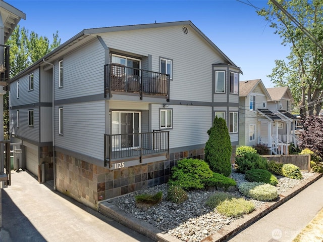 1125 N 93rd St Unit 6, Seattle, WA 98103 - view of property exterior with a balcony, a garage, and a residential view