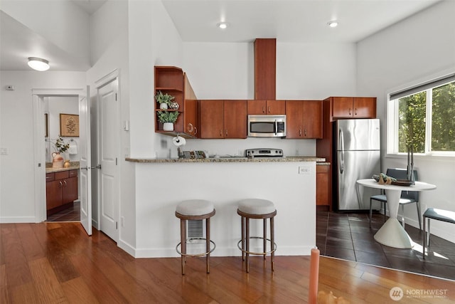 1125 N 93rd St Unit 6, Seattle, WA 98103 - kitchen with appliances with stainless steel finishes, open shelves, dark wood finished floors, a peninsula, and a breakfast bar