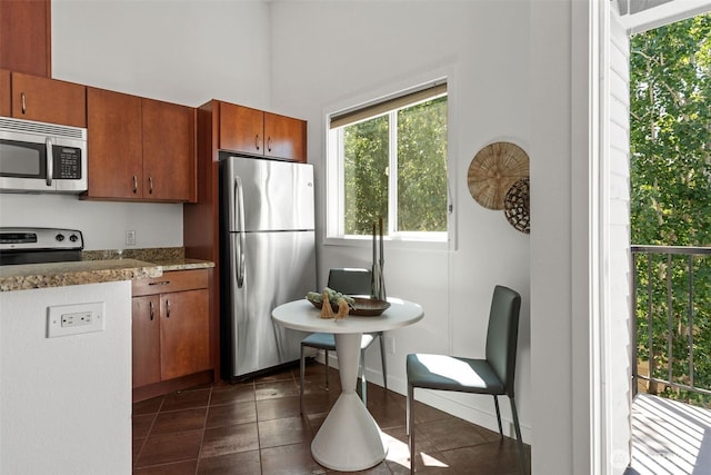 1125 N 93rd St Unit 6, Seattle, WA 98103 - kitchen featuring stainless steel appliances, dark tile patterned flooring, brown cabinetry, and a high ceiling
