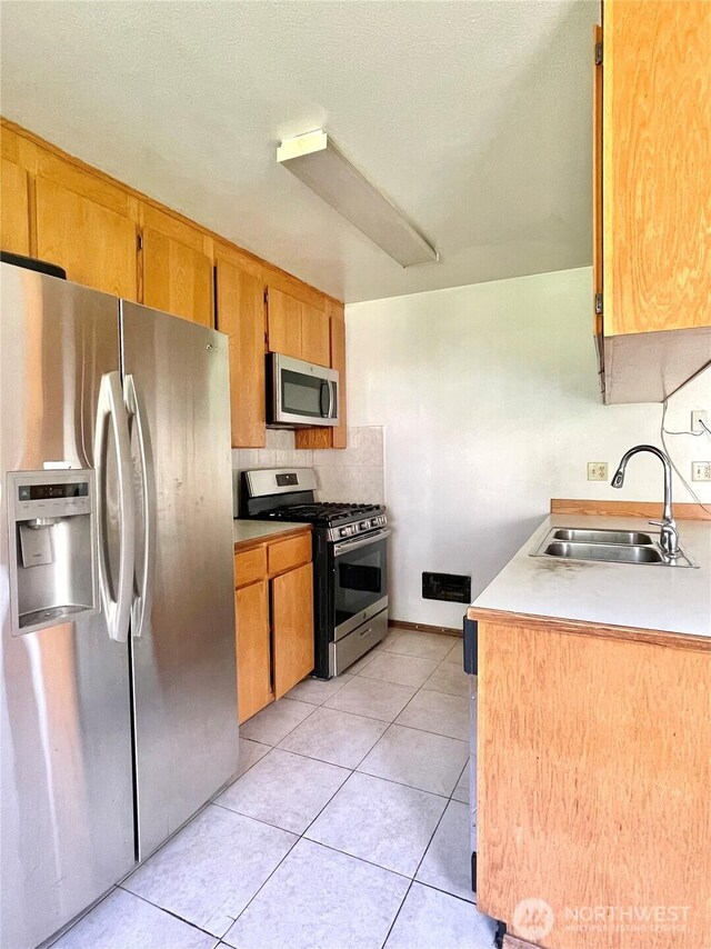 59G Copple Rd, Omak, WA 98841 - kitchen with stainless steel appliances, light countertops, light tile patterned flooring, and brown cabinets