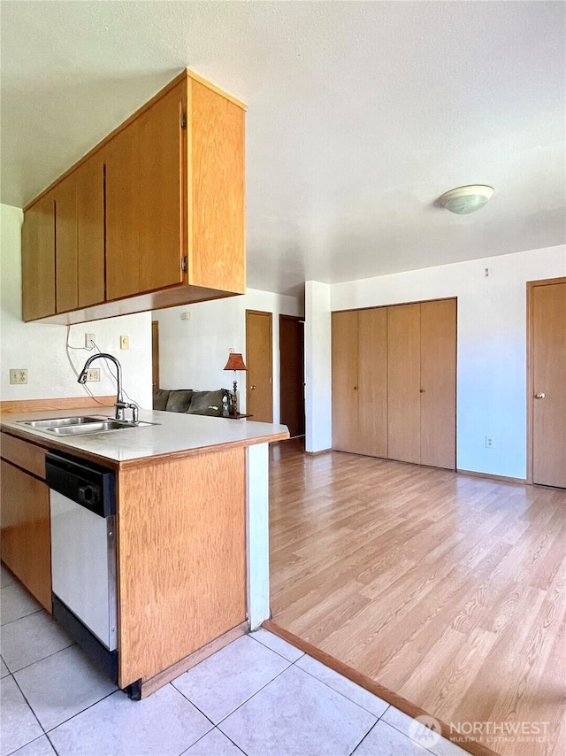 59G Copple Rd, Omak, WA 98841 - kitchen featuring white dishwasher, light countertops, light wood finished floors, open floor plan, and brown cabinetry