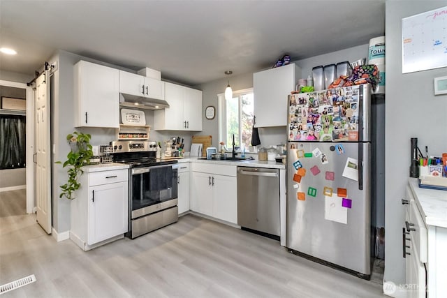 19820 63rd Avenue Ct E, Spanaway, WA 98387 - kitchen with stainless steel appliances, under cabinet range hood, light wood-type flooring, light countertops, and recessed lighting
