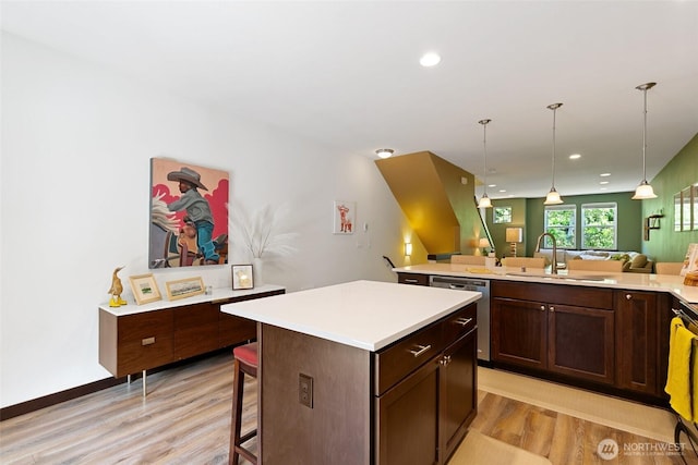 7162 Shinkle Pl SW Unit 64, Seattle, WA 98106 - kitchen featuring dishwasher, a kitchen island, light wood-style flooring, a breakfast bar area, and open floor plan