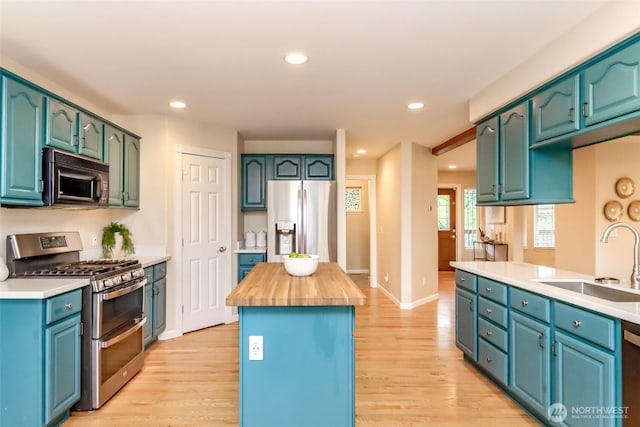 3112 87th Avenue Ct E, Edgewood, WA 98371 - kitchen with appliances with stainless steel finishes, light wood finished floors, a center island, recessed lighting, and wood counters